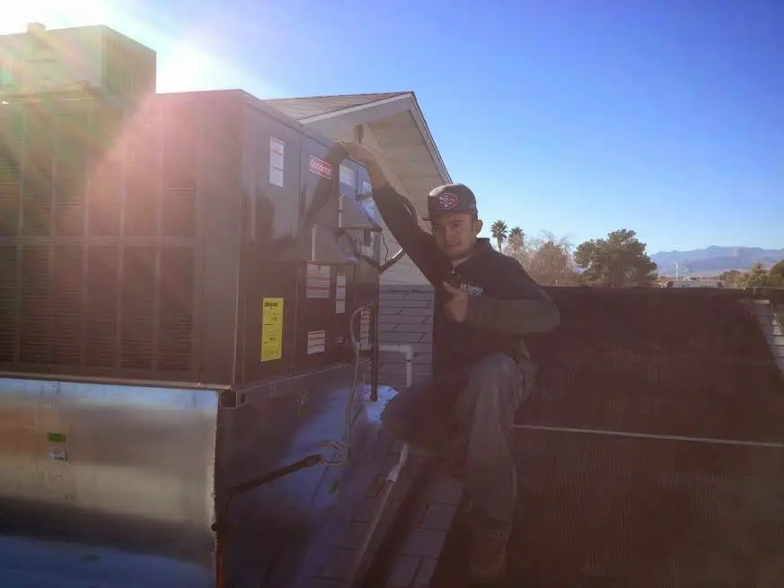 HVAC technician performing Air Duct Repair on a rooftop unit in Wake Forest